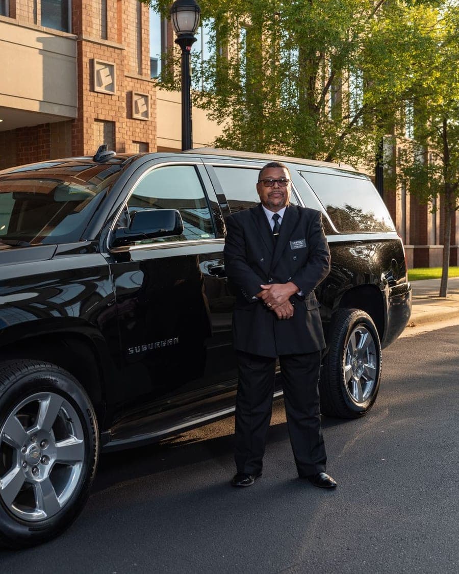 Chauffeur devant un véhicule de transport professionnel